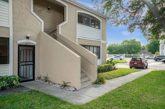 Front view of a two-story residential building with stairs leading to the upper level.