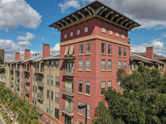 Front view of a multi-story residential building with balconies and decorative chimneys.
