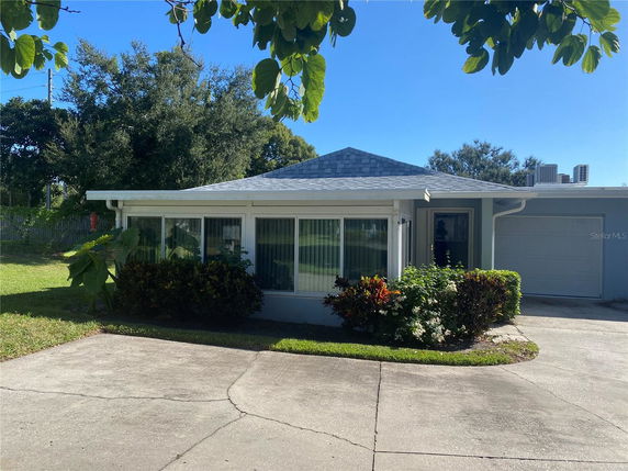 Front view of a single-story house with a garage and large windows.