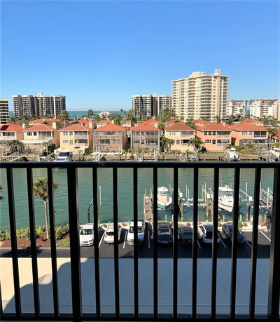 Panoramic view of waterfront buildings and parked boats from a high vantage point.