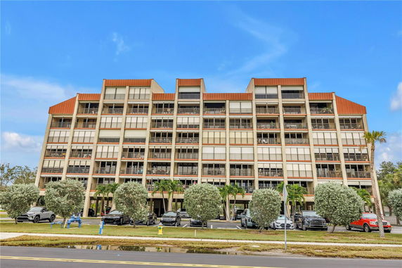 Front view of a multi-story apartment building with balconies.