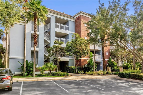 Front view of a multi-story apartment building with staircases and balconies.