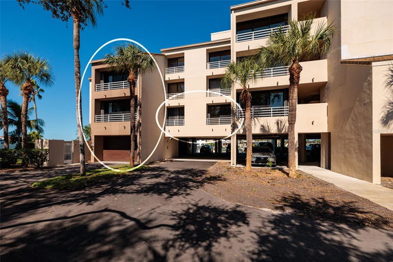 Front view of a multi-story building with palm trees.