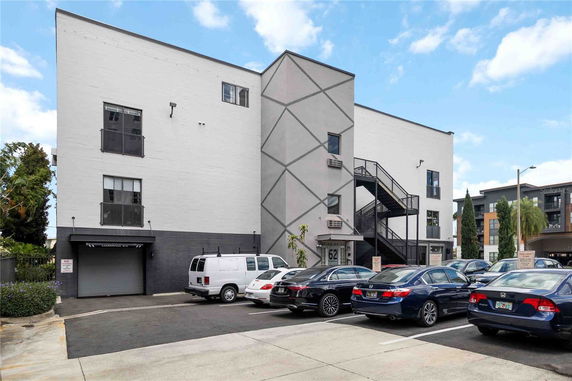 Front view of a multi-story building with an external staircase.