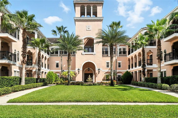 Front view of a multi-story residential building with a central tower and balconies.