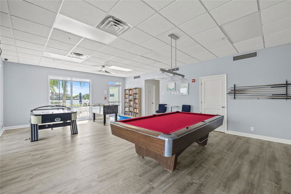 Room with a pool table, air hockey, and foosball table.