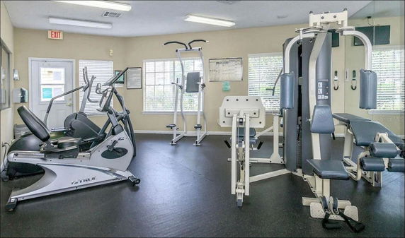 Indoor gym area with exercise equipment and machines.