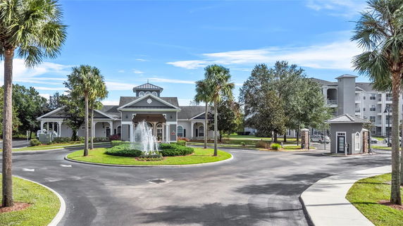 Front view of a large building with a central entrance, surrounded by a driveway and landscaping.