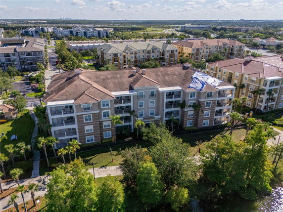 Aerial view of apartment buildings with multiple stories and surrounding greenery.