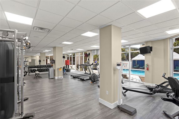 Interior view of a gym with exercise equipment including treadmills and weights.