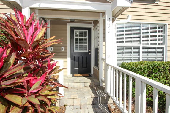 Front view of a house entrance with a black door and white window shutters.