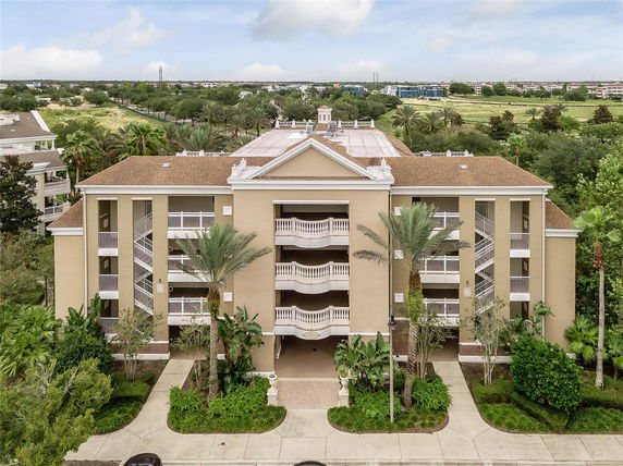 Front view of a multi-story apartment building with balconies and exterior stairs.