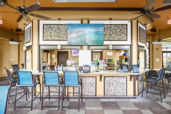 Indoor view of a bar area with seating and a display of bottles.