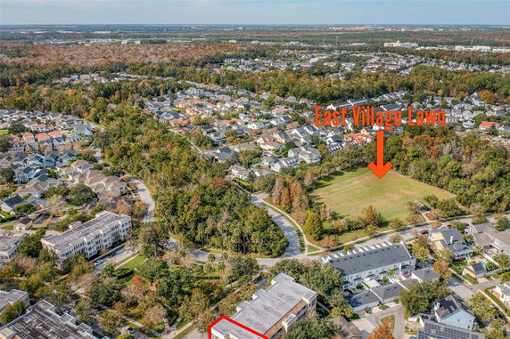 Aerial panoramic view of a residential neighborhood with a grassy area labeled 'East Village Lawn'.