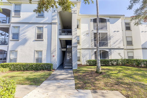 Front view of a multi-story apartment building with exterior stairs.