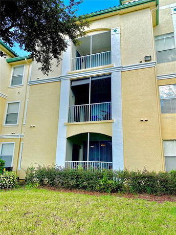 Front view of a multi-story building with balconies and green roofing.