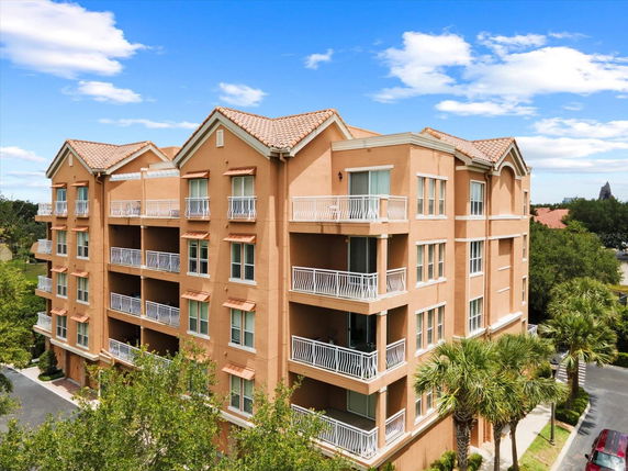 Front view of a multi-story building with balconies and a tile roof.