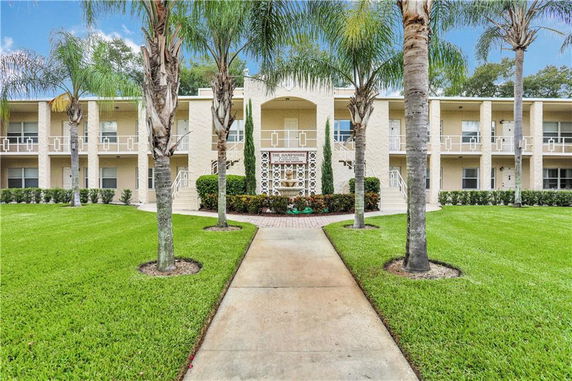 Front view of a two-story apartment building with a central entrance and symmetrical design.