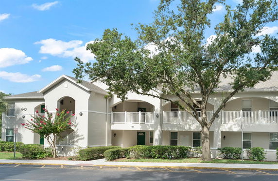 Front view of a two-story residential building with balconies and white railings.