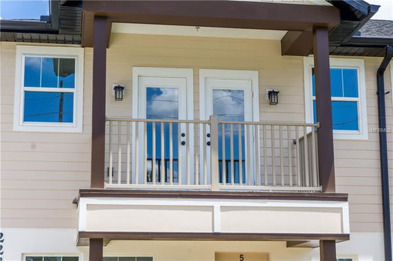 Front view of a house with a small balcony and two glass doors.