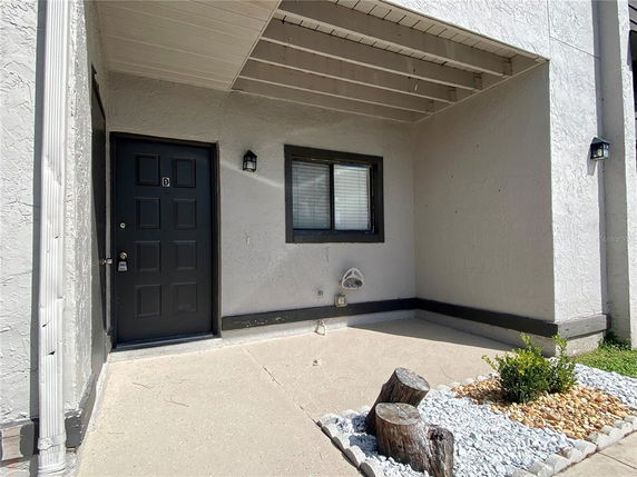 Front view of a house entrance with a covered porch and a black door.
