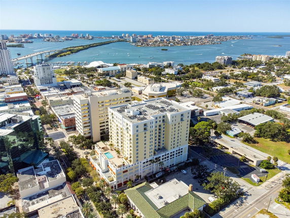 Aerial view of city buildings with water bodies and islands in the background.