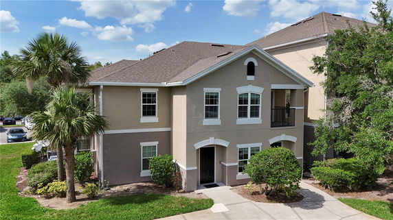 Front view of a two-story house with a small balcony and multiple windows.