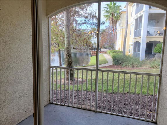 View from a balcony overlooking a pond and nearby building.