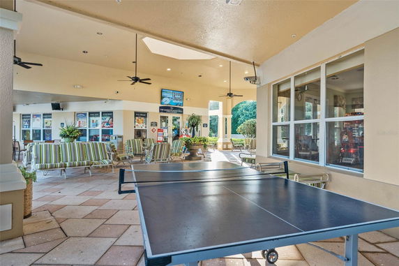 Indoor recreational area with table tennis and seating.