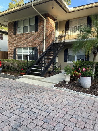 Front view of a two-story building with a brick facade and exterior staircase.