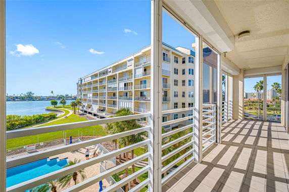 View from a building balcony overlooking a waterfront and adjacent apartment complex.