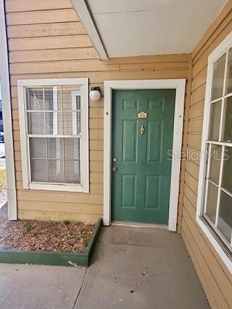Front view of a house entrance with a green door and beige siding.