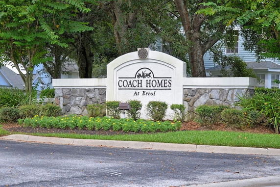 Entrance sign of Coach Homes community with stone and white structure.