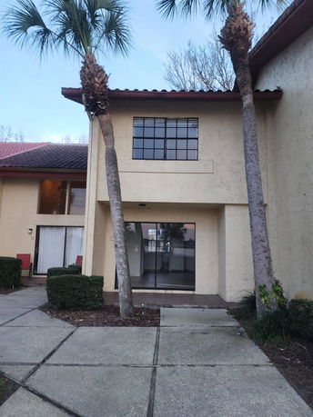 Front view of a two-story house with large windows and a tiled roof.