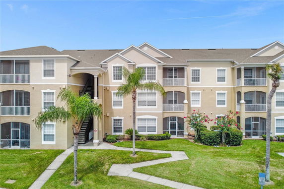 Front view of a multi-story apartment building with arched balconies.