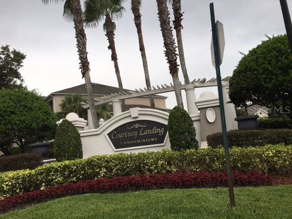 Entrance sign of Courtney Landing Condominiums with surrounding landscaping.