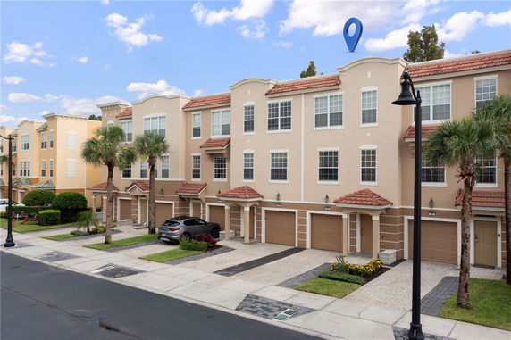 Front view of a multi-story townhouse building with garages and driveways.