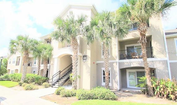 Front view of a multi-story building with balconies and exterior stairs.