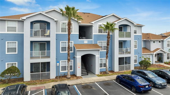 Front view of a three-story apartment building with a blue and white facade.
