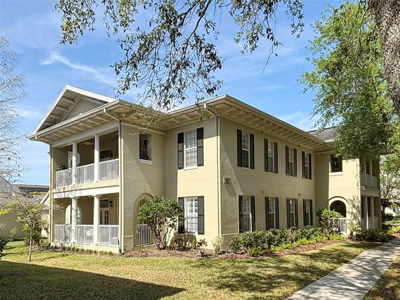 Front view of a two-story house with a large balcony and multiple windows.