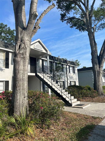 Front view of a two-story residential building with an exterior staircase.