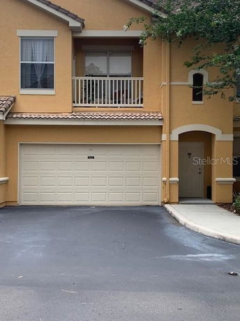 Front view of a townhouse with a double garage and small balcony.