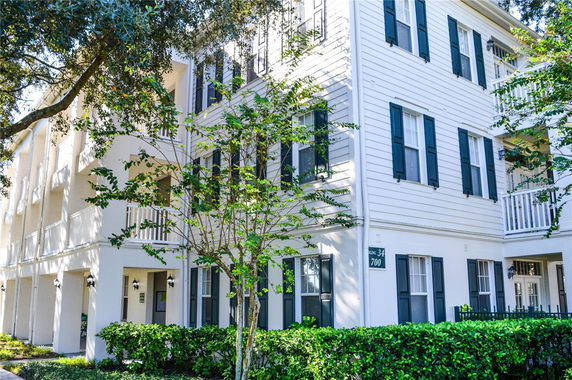 Front view of a multi-story building with white siding and blue shutters.