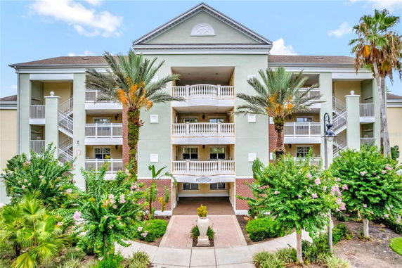 Front view of a multi-story residential building with balconies and a decorative entrance.