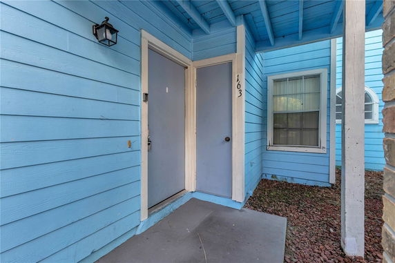Front view of a house with blue siding and a covered porch area.