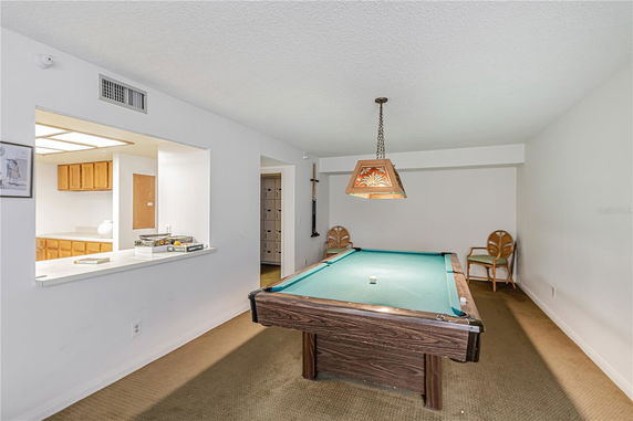 Indoor recreation area with a pool table and seating.