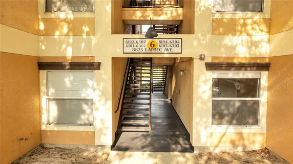 Front view of a multi-story building entrance with stairs leading up.