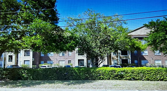 Front view of a multi-story apartment building with brick facade.