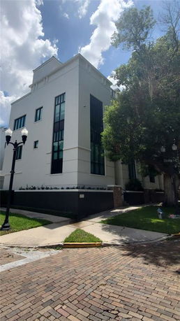 Front view of a modern multi-story building with large windows and a clean white facade.