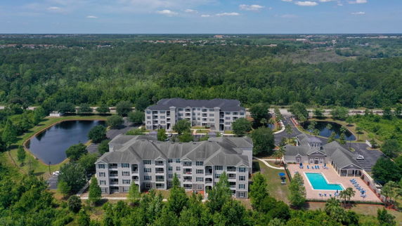 Panoramic view of residential complex with swimming pool and surrounding greenery.
